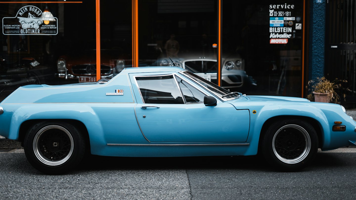Light blue vintage sports car parked on a street.