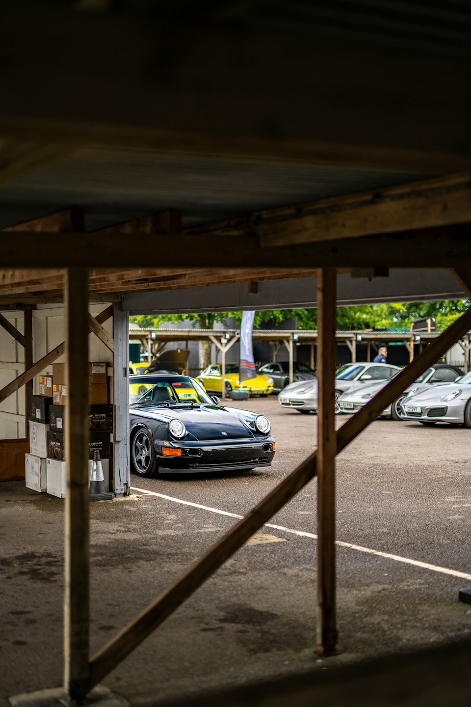 A black vintage sports car parked in an outdoor lot.